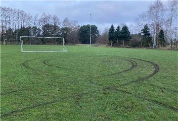 Reifenspuren führen über den Sportplatz in Federlohmühlen bei Kirchwalsede.