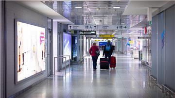 Reisende gehen am Morgen mit Koffern durch den Flughafen Hannover-Langenhagen.