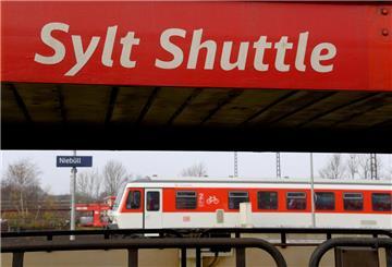 Ein Wagen des Autozuges Syltshuttle und ein Nahverkehrszug sind zu sehen.