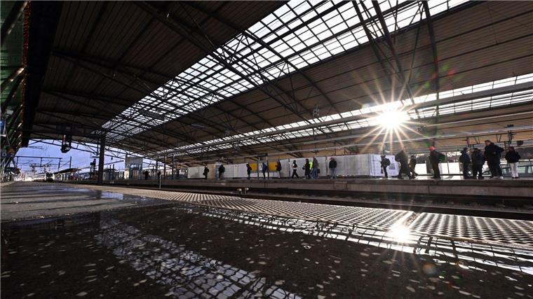 Reisende warten auf einen Zug im Hauptbahnhof.