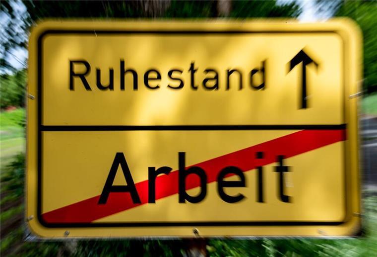 Bürgergeld im Alter: Wann Rentner Anspruch haben Ein Schild steht am Straßenrand in der Optik eines Ortsschildes, auf dem das Wort "Arbeit" durchgestrichen und der Weg Richtung "Ruhestand" ausgeschildert ist.