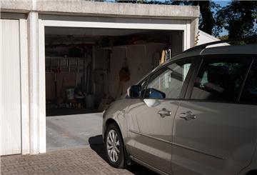 Ein silbernes Auto steht vor einer Garage.