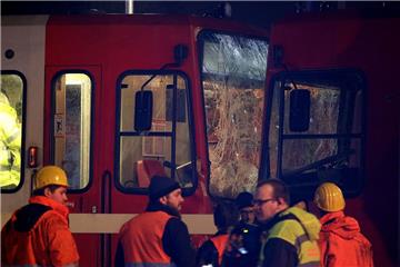 Rettungskräfte stehen vor den beiden Straßenbahnen, die in Köln zusammengestoßen sind. 