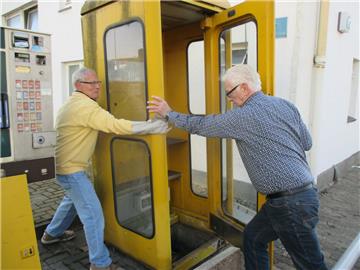 Rolf Wilhelm (links) und Manfred Rommel aus Leherheide geben der letzten Bremerhavener gelben Telefonzelle das Gnadenbrot: Als Bücherschrank. 