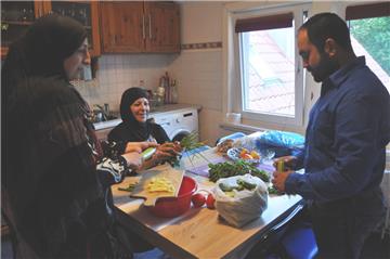 Rosha Al Rifai (links) und ihre Mutter Ayda bereiten das „Iftar“ zu. Roshas Ehemann Abdullah hilft beim Aushöhlen kleiner Zucchini mit.