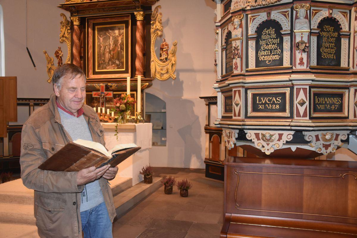Rudolf Meyer leitet die Gruppe der Kirchenöffner in Sittensen. Der 72-Jährige freut sich beim Blick ins Gästebuch über die freundlichen Eintragungen.  