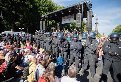 Rückblick auf den 1. August: Polizisten stehen bei einer Kundgebung gegen die Corona-Beschränkungen auf der Straße des 17. Juni zwischen Teilnehmern vor einer Bühne. Die Polizei hatte damals die Veranstaltung aufgelöst. 