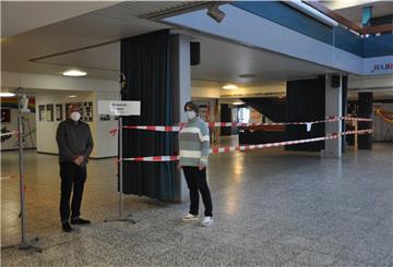"Ruhezone Abitur": Im Kreisgymnasium ist für die Prüfungen ein kompletter Gebäudetrakt mit Flatterband abgetrennt worden, den hier Schulleiterin Birgit Becker und Kunstlehrer Ulrich Buja präsentieren.