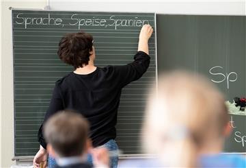 Lehrerin schreibt an der Tafel