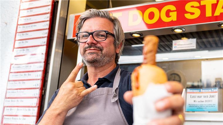Der H-Blockx-Sänger und die Dobermannwelpen Sänger Henning Wehland („H-Blockx“) 2022 an einem Hot Dog-Stand in Münster.