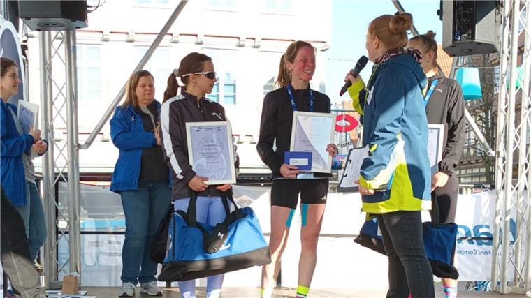 Zwei Frauen in Sportkleidung mit Urkunden in der Hand