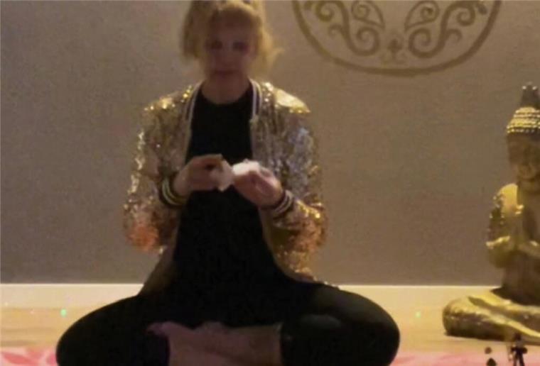 Frau sitzt neben Buddha-Figur
