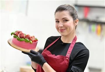 Frau zeigt eine Wursttorte