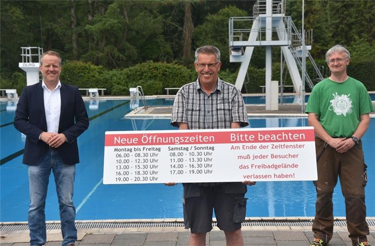 Samtgemeindebürgermeister Jörn Keller, Schwimmmeister Udo Grönboldt und sein Kollege Björn Herold (von links) weisen auf die neuen Öffnungszeiten des Sittenser Freibades hin.
