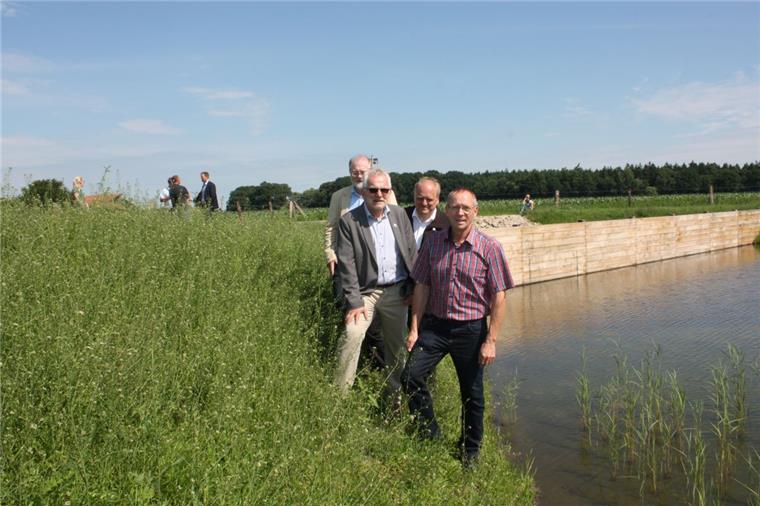 Saubere Sache: Ingenieur Hans Wilhelm Hammerich (Born & Ermel), Bürgermeister Ulf Voigts, Bauunternehmer Ralf Mehrtens und Ortsvorsteher Wilfried Geils stellen das Rückhaltebecken mit Bodenfilter vor. Im Hintergrund die Tauchwand aus Holz, die Schwimmstoffe zurückhalten soll.  