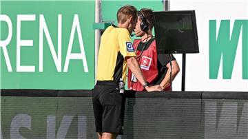 Schiedsrichter Sascha Stegemann schaut sich das umstrittene Bremer Handspiel am Bildschirm an.
