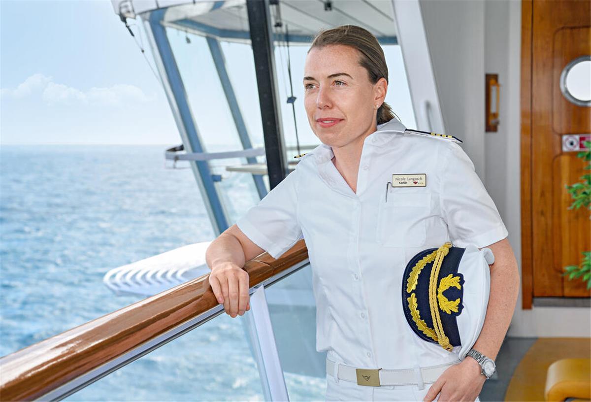 Frauen sind auf Kreuzfahrtschiffen deutlich in der Unterzahl eine Frau in Kapitänsuniform steht an der Reling eines Schiffes