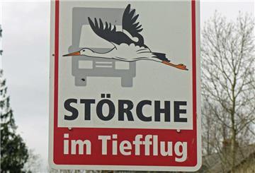 Schilder warnen vor tieffliegenden Störchen.