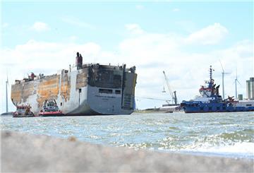 Schlepper ziehen den schwer beschädigten Autofrachter „Fremantle Highway“ in den Hafen.