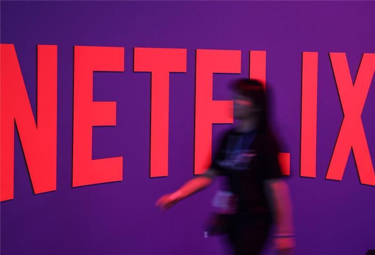 Eine Frau geht am Stand von Netflix vorbei.
