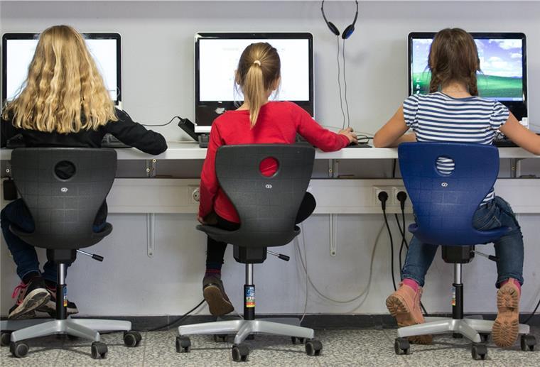 Schülerinnen arbeiten in einem Klassenraum einer Grundschule an Computern.