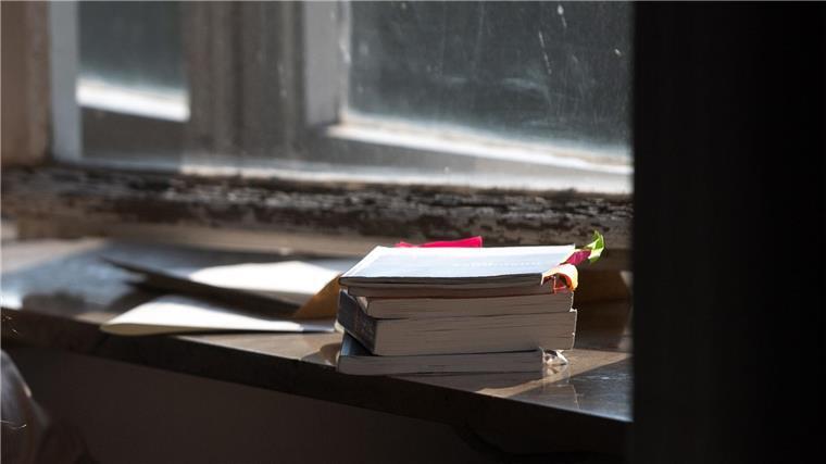 Schulbücher liegen auf einer Fensterbank.