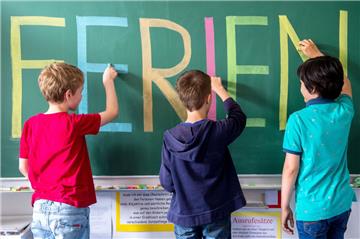 Schulkinder schreiben mit bunter Kreide das Wort "Ferien" an eine Tafel. In den sechswöchigen Sommerferien bietet die Samtgemeinde Selsingen demnächst eine maximal zweiwöchige Betreuung für Shculkinder an.