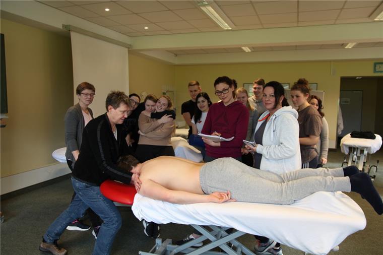 Schulleiterin Susann Agthe (links) zeigt Anja Rock (roter Kapuzenpullover)  und Wiebke Schüler (rechts davon) sowie den anderen Physiotherapie-Schülerinnen und -Schülern die richtigen Handgriffe.Foto: Gehrke