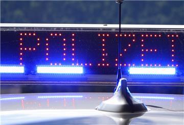 Mit Blaulicht und der Anzeige "Polizei“ steht ein Polizeifahrzeug bei einer Verkehrskontrolle.