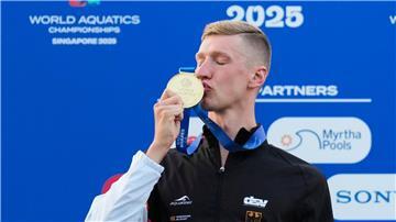 Schwimmer Florian Wellbrock küsst seine Goldmedaille. Die hat er sich gerade bei der Schwimm-WM im Land Singapur geholt.
