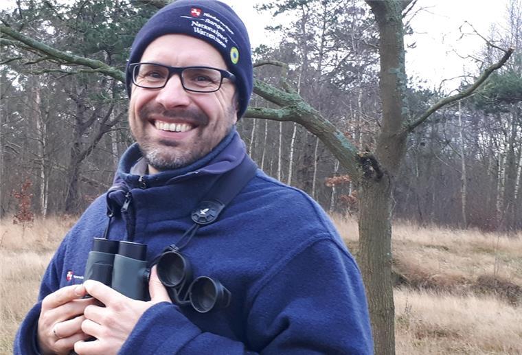 Mann mit Fernglas im Wald