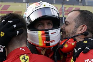 Sebastian Vettel vom Team Scuderia Ferrari freut sich mit Mitgliedern aus seinem Team über seine Leistung.