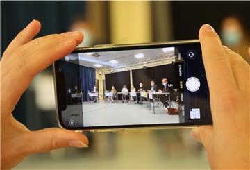 Eine junge Frau hält ein Smartphone in der Hand.