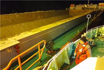 Seenotretter im Einsatz für einen Seemann, der auf der Elbe über Bord von einem Frachtschiff gestürzt war. Seenotrettungskreuzer „Anneliese Kramer“ längsseits am Baggerschiff "Pieter Caland", das den Mann gerettet hat.