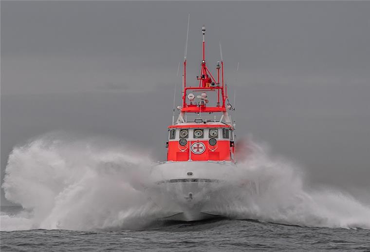 Seenotretter holen verletzten Matrosen von Containerschiff Seenotrettungskreuzer „Theo Fischer“ auf dem Wasser mit Wellen