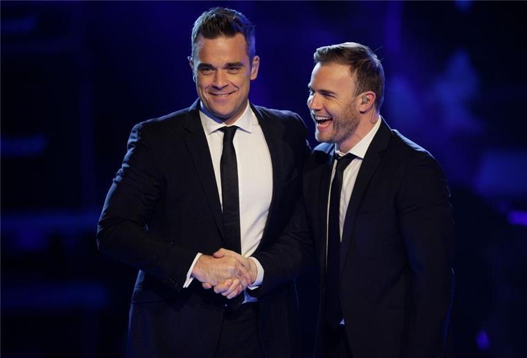 Take-That-Rebell und Familienvater: Robbie Williams wird 50 Seine verbalen Angriffe gegen seine Take-That-Kollegen, insbesondere Gary Barlow, sind Williams heute peinlich. Auf dem Foto treten die beiden Sänger in der Castingshow „Popstars - Girls Forever“ in Köln auf (Archivbild).