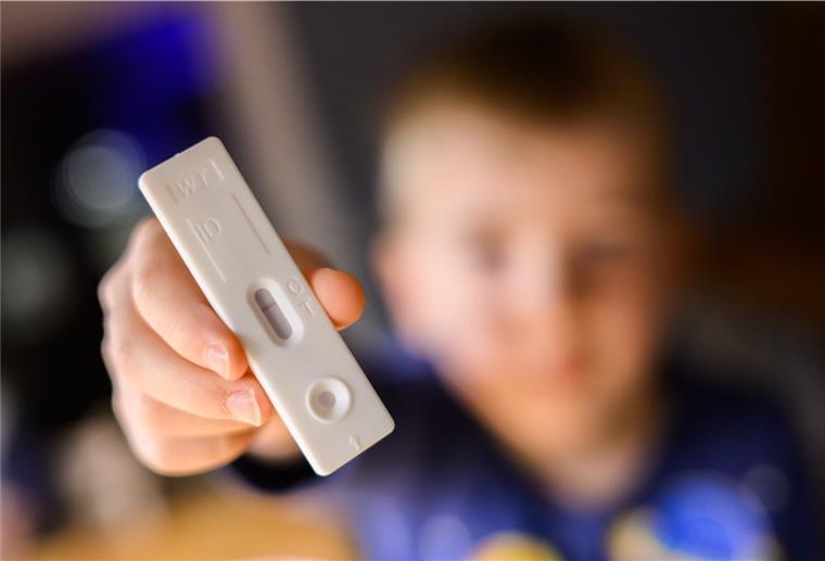 Ein fünfjähriger Junge zeigt einen negativen Corona-Selbsttest (gestellte Szene)