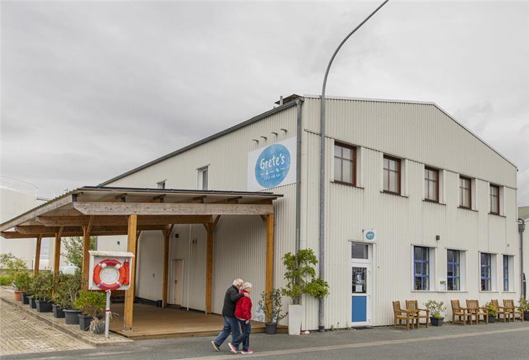 Eine alte Industriehalle, jetzt ein Café: Davor laufen Spaziergänger.