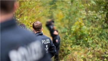 Männer in einem Wald mit der Aufschrift Polizei auf dem Rücken.