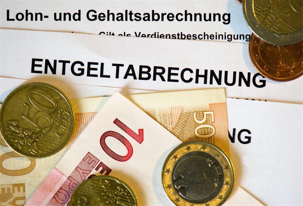 Mindestlohn vs. Bürgergeld: Studie deckt krassen Unterschied beim Einkommen auf! Auf Lohn- und Gehaltsabrechnungen (Entgeltabrechnungen) liegen Euromünzen und Eurogeldscheine. Der Mindestlohn legt fest, wie viel Geld jemand wenigstens bekommt für eine Stunde Arbeit.