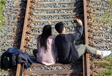 Ein Paar macht auf den Gleisen  ein "Selfie" 