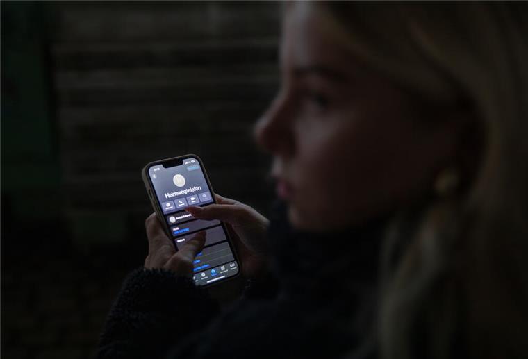 Mit Anruf sicher nach Hause: So funktioniert das Heimwegtelefon Frau mit Handy