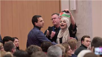 Sicherheitskräfte führen eine pro-palästinensische Zuschauerin nach Zwischenrufen aus dem Saal.