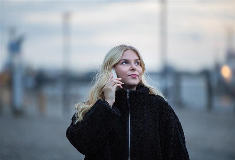 Mit Anruf sicher nach Hause: So funktioniert das Heimwegtelefon Frau mit Handy