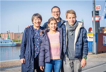 Sie sind die Familie des 1973 ausgewanderten Jugoslawn Franjo Spahic: Sein Sohn Marinko, sein Enkel Samuel, Ehefrau Susanne und Enkelin Olivia spazieren gern an der Kaje des Neuen Hafens entlang, an der nicht nur einst Spahics erster Arbeitsplatz war, sondern inzwischen auch das Auswandererhaus unter anderem seine Geschichte erzählt. Franjo Spahic ist 2016 verstorben. Sein Foto an der DAH-Fassade wird künftig an ihn erinnern.
