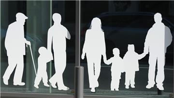 Silhouetten von Menschen in verschiedenem Alter sind auf Fensterscheiben aufgeklebt.