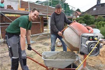 Sind gerne auf der Baustelle: Stefan Schmitchen (links) und Jens Kühne-Sievers. Als Handlanger reichen sie den Maurern die Mischungen.