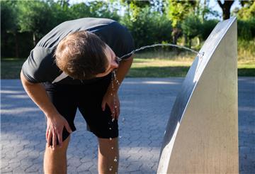 Ein Sportler trinkt Wasser an einem öffentlichen Trinkwasserspender.