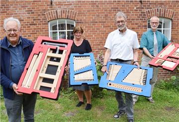So sieht der Orgelbaukasten aus. In ihren Händen halten ihn (von links): Helmut Bahlmann (Arp-Schnitger-Gesellschaft), Wibke Heumann (Leiterin der Grundschule Golzwarden), Hans-Peter Tapken (Arp-Schnitger-Gesellschaft) und Kreiskantor Gebhard von Hirschhausen.
