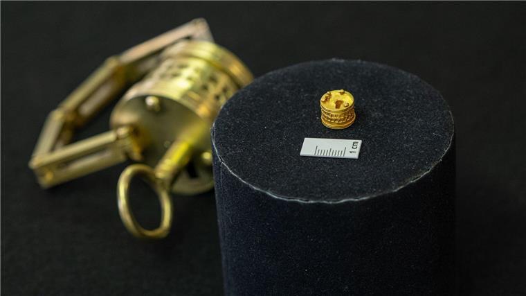 Römisches Mini-Dosenschloss aus Gold gibt Rätsel auf So winzig: Das römische Miniatur-Schloss liegt neben einem Maßstab für einen Zentimeter. Im Hintergrund der Nachbau im Verhältnis 4:1.